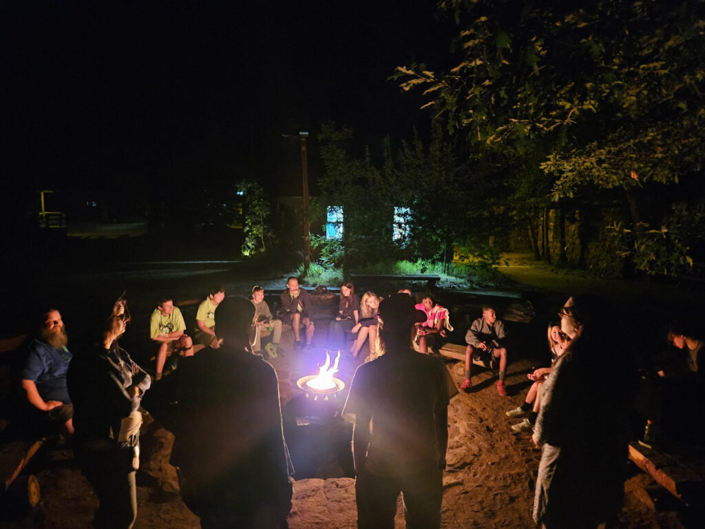 Camp Quest Arizona campers and staff gathered around a campfire at night in Prescott