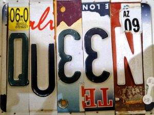 License plate art spelling "QUEEN" at Pop Cycle, showcasing unique LGBTQ-friendly art in Tucson.