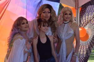 Image of 3 drag queens posing with a girl
