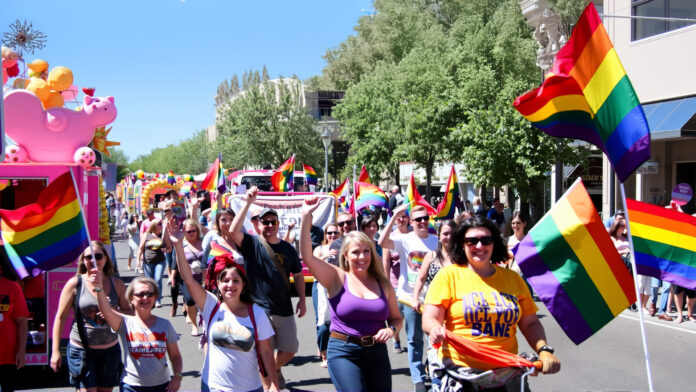 A diverse group of people celebrating LGBTQ+ culture at Tucson’s Pride in the Desert parade.