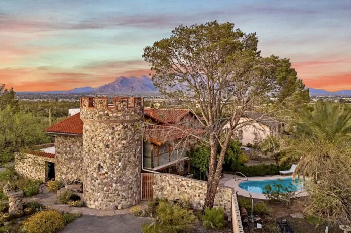 Allure of the Desert boutique resort in Tucson, showing a castle-style stone building, pool, desert landscape and mountain views at sunset.